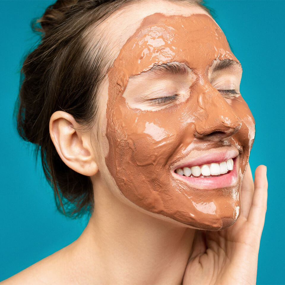 woman applying clay face mask